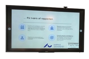 Foto af en skærm med et slide om rapporten